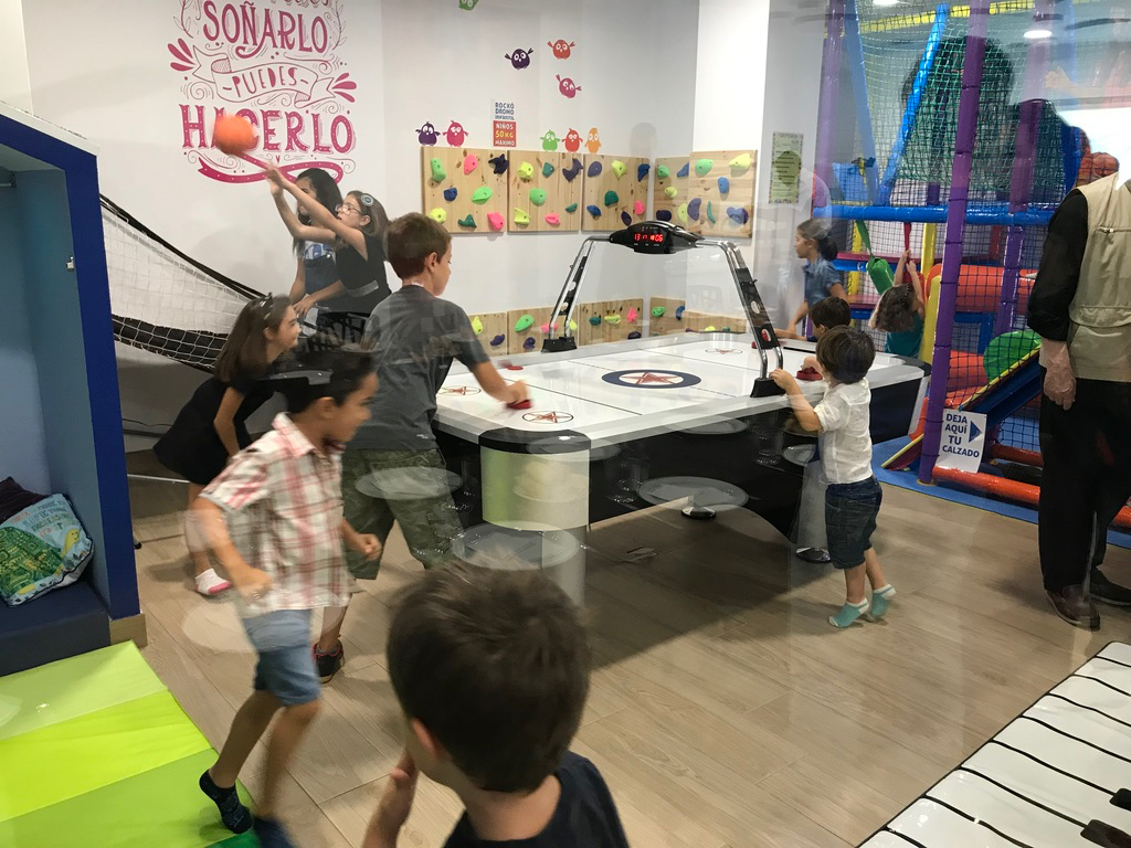 Sala de juegos con air hockey y rocódromo